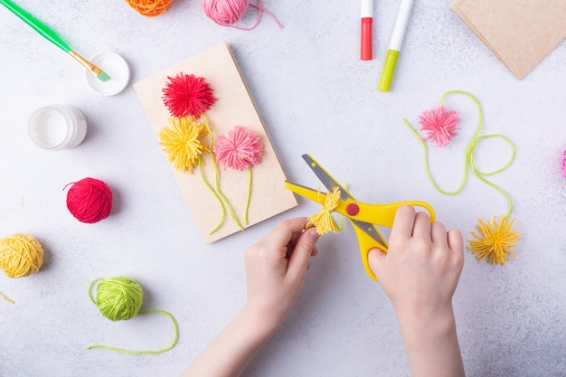 母の日行進や誕生日の小さな子供のためのペーパークラフトは、色紙とお母さんのための色の編み球から花の花束をやっていますシンプルなギフトのアイデアトップコピースペース高品質の写真を見る