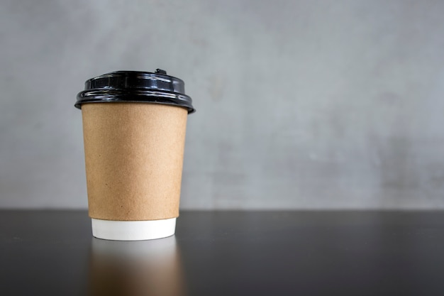 Foto tazza di caffè di carta sulla tavola nera