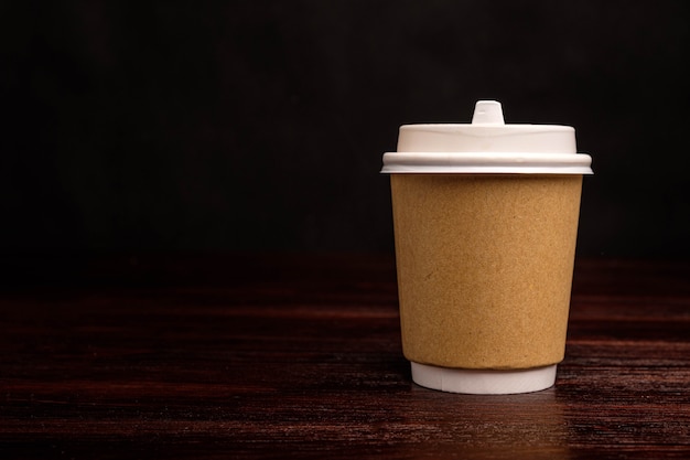 Paper cup for coffee on a dark background