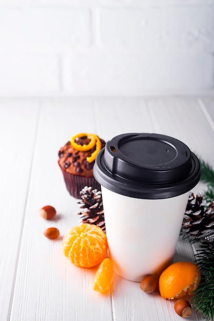 Paper cup of coffee surrounded by Christmas decorations