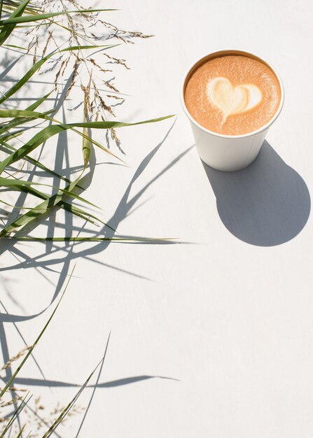 Paper cup of coffee on a white.