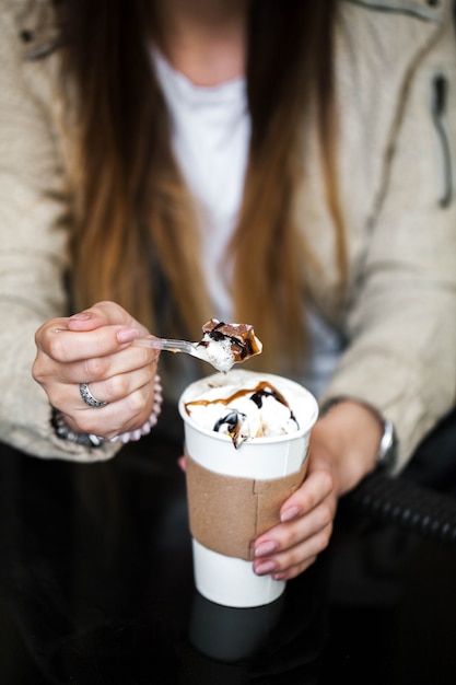 Paper cup with coffee in hand at the girl