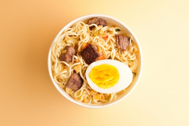 Paper cup with instant ramen noodles with beef and vegetables