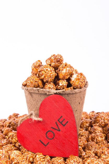 Paper cup with popcorn and red heart