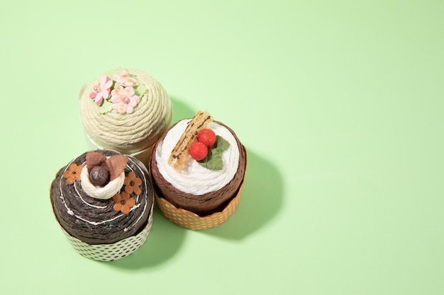 Paper cupcakes on light green background