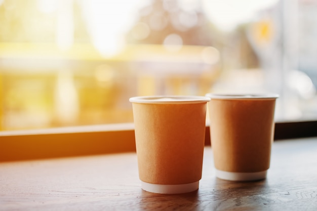 Paper cups of coffee near the window of cafe