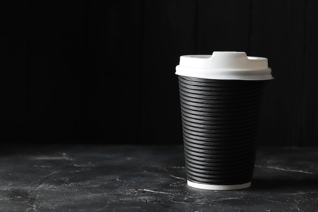 Paper cups of coffee on table on dark background. Mockup design. Place for text. A place for the logo.