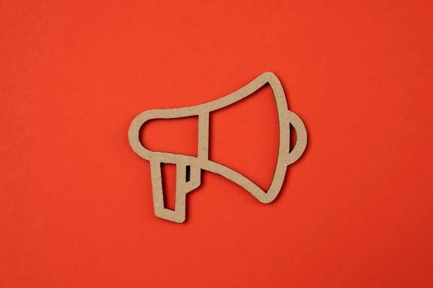 Paper cut cardboard megaphone on red background