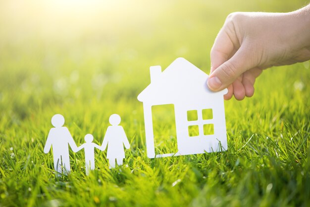 Paper cut family with house in green grass