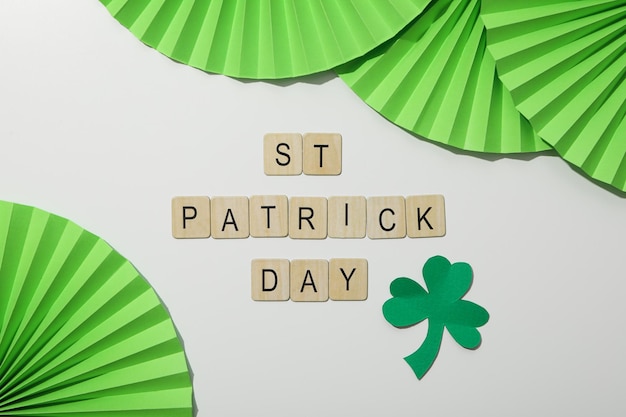 Paper decoration and clover leaf wooden letters on white background top view