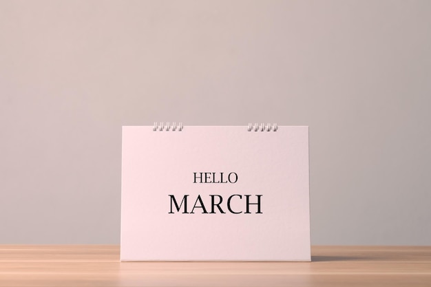 Фото Бумажный настольный календарь с текстом hello march на деревянном столе с серой стеной