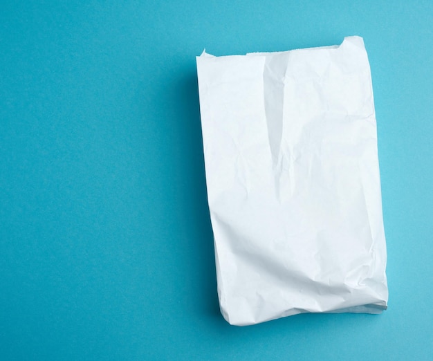 Photo paper disposable food bag on a blue background concept of delivery and ordering food top view