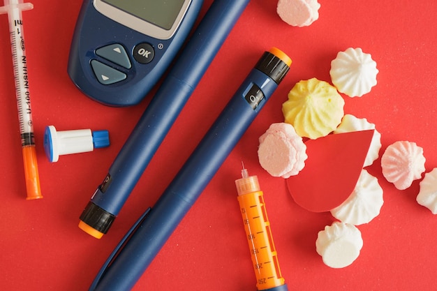 Photo a paper drop of blood and a lot of syringe pens with insulin