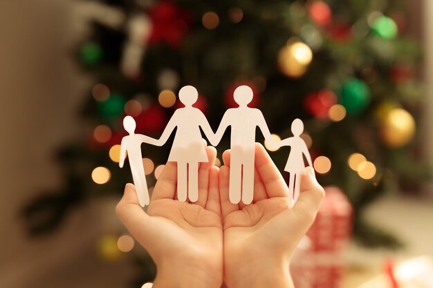 paper family on the background of a Christmas tree