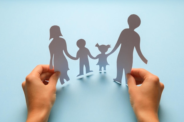 Paper family in hand isolated on blue background