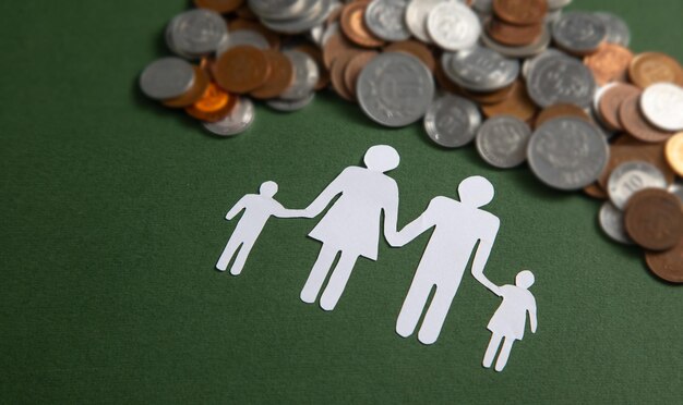 Paper family with a coins on the green background