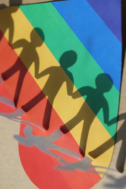 Photo paper figures of people and shadows on background of lgbt heart development of relations in