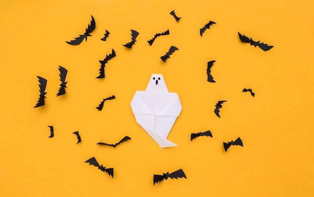 Paper flying bats, ghost on yellow background. halloween background. top view. flat lay