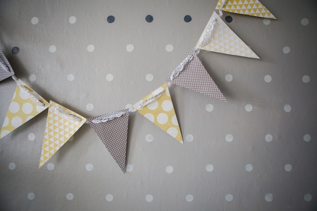 Photo paper garland against the grey wall with dots