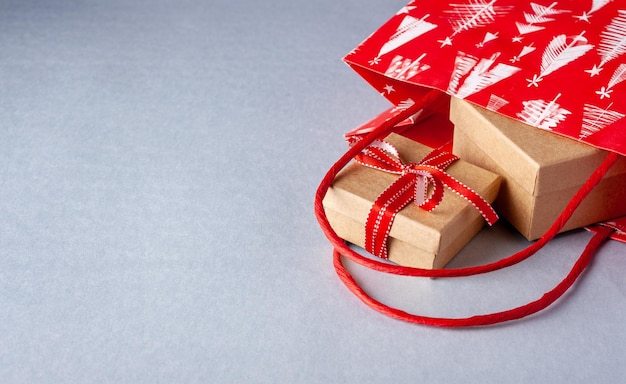 Paper gift bag and kraft boxes tied with red ribbon copy space boxing day