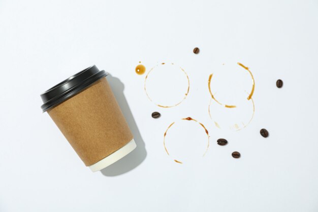 Paper glass, coffee beans and rings on white background