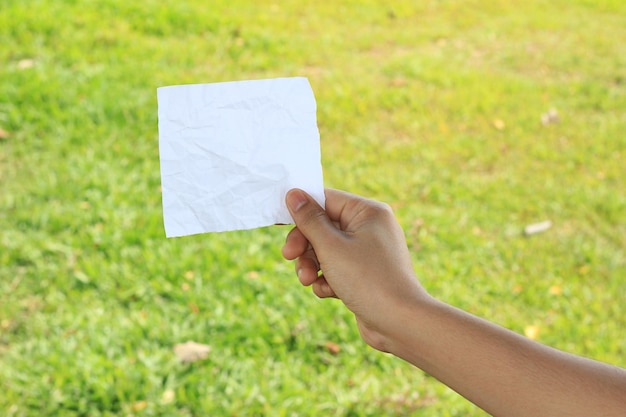 paper in hand on grass background