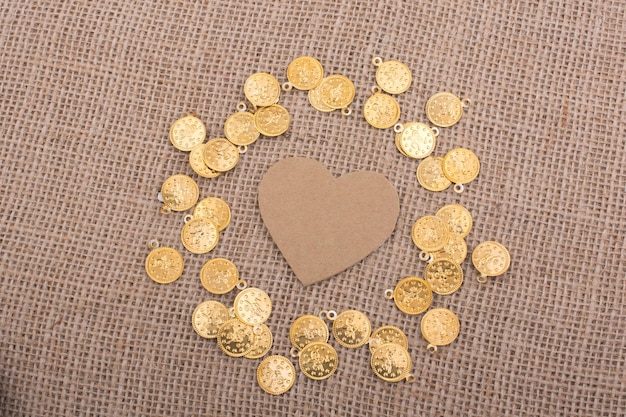 Photo paper heart with fake coins around it