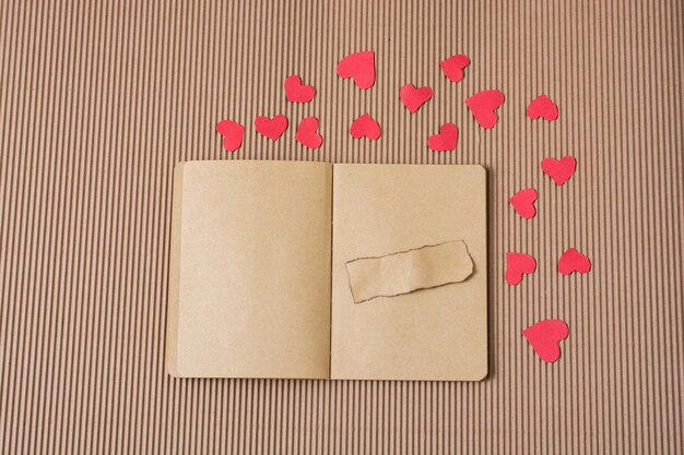 Paper hearts around notebook with torn paper