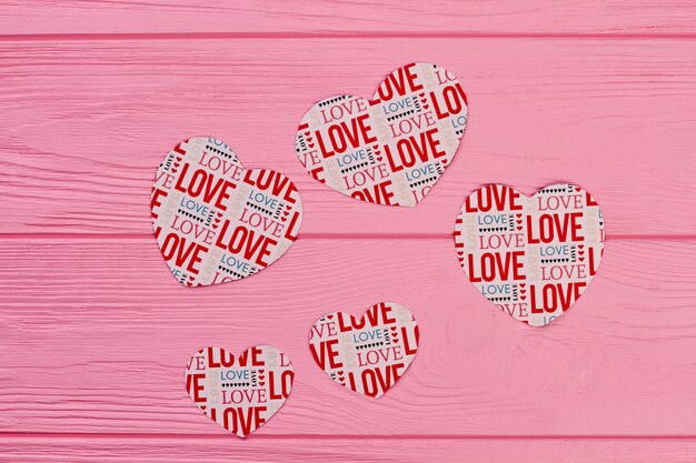 Photo paper hearts for banner on wooden background.