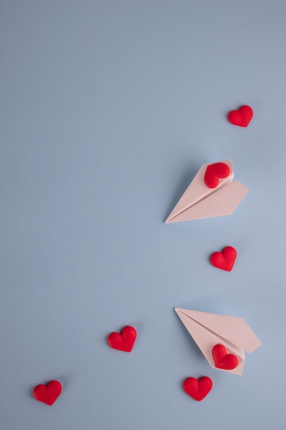 Paper and hearts on pastel blue table.