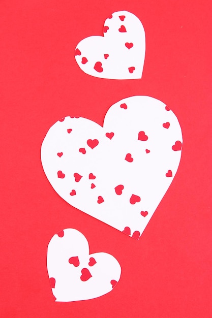 Photo paper hearts on red background