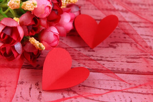 Paper hearts with flowers on table close up