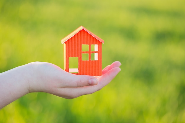 Paper house in hand outdoor