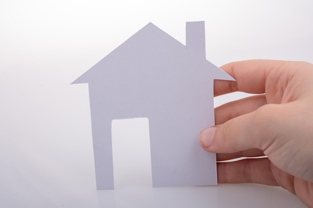 Paper house in hand on a white background