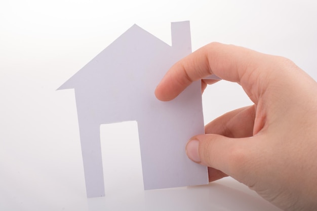 Paper house in hand on a white background