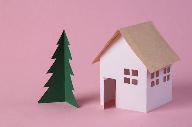 Paper House model and a Christmas tree on pink background