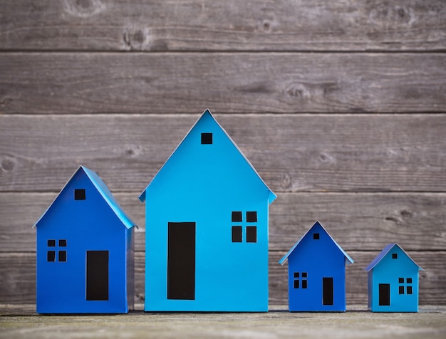 A paper houses stands over a wooden background