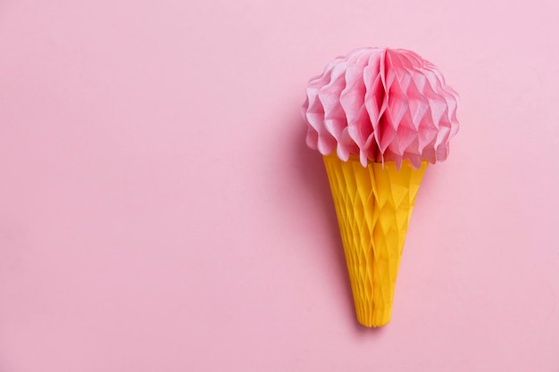 Photo paper ice cream cone decoration on a pastel pink background