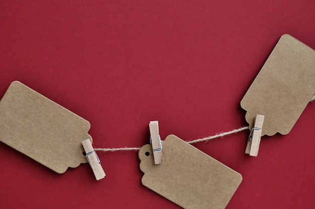 Photo paper labels are attached with clothespins to the rope on red.