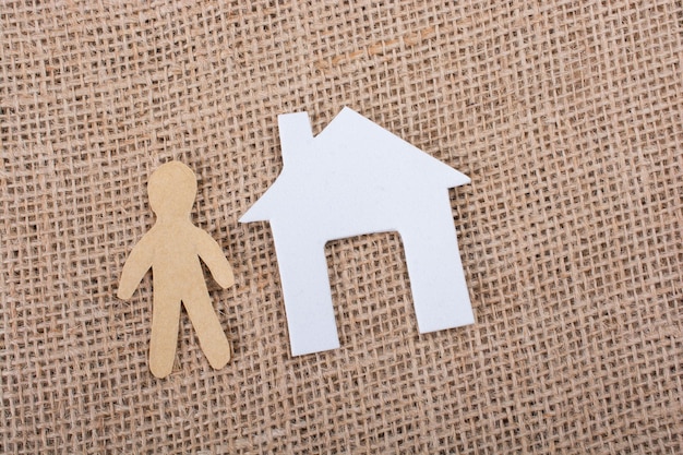 Paper man shape beside a house shape