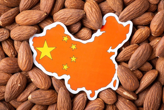 Paper map and flag of China on almond nuts Concept of growing almond in China origin of almond