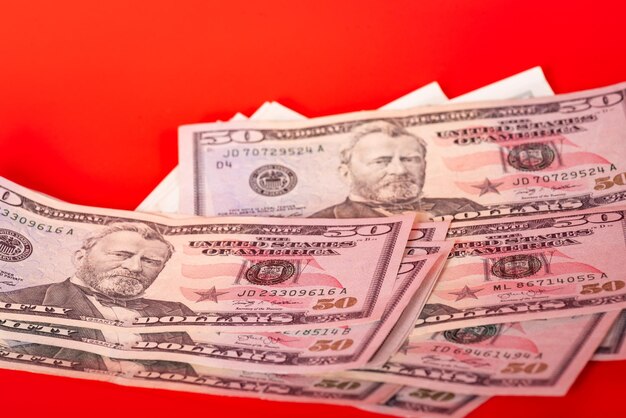 Photo paper money american dollars a lot on a red background. financial concept.