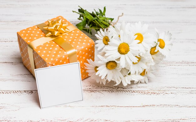 Бумага возле подарка и букет цветов