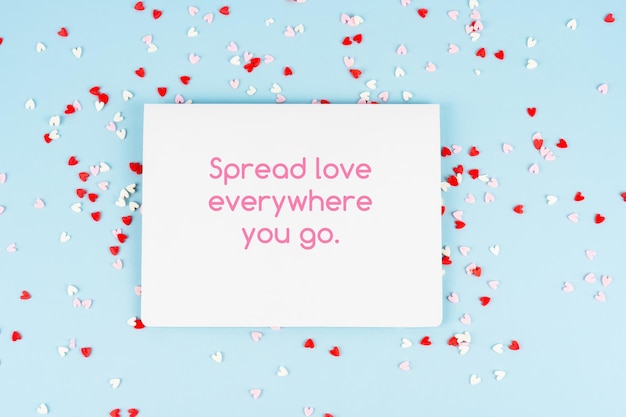 Paper note and confetti with inspirational quotes text Spread love everywhere you go