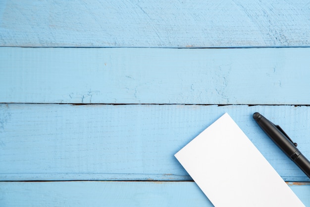 Foto taccuino di carta e penna nera su legno blu