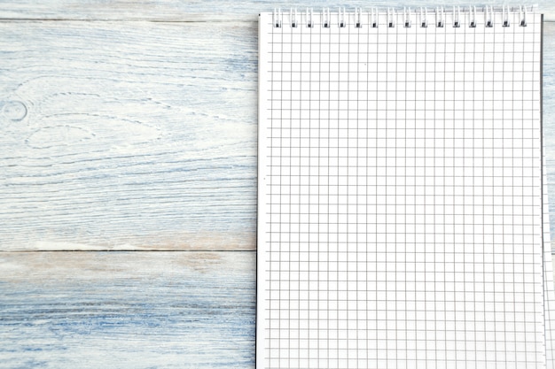 Photo paper notebook with space for text on a light blue old wooden background.