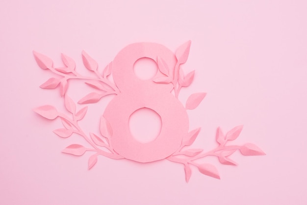 paper number 8 and leaves on pink background