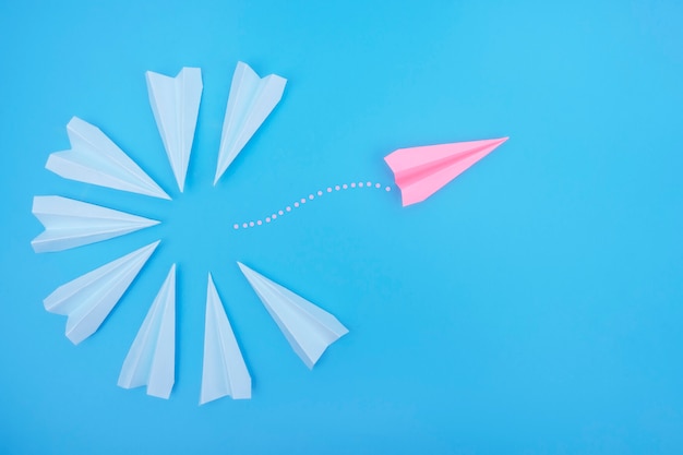 The paper plane flies in the opposite direction from the others.