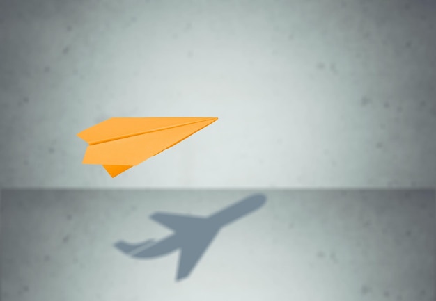 Бумажный самолетик в полете с тенью