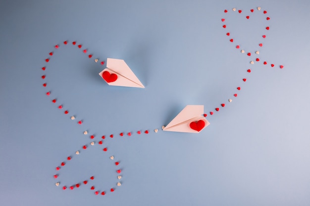 Paper planes flying with heart candies